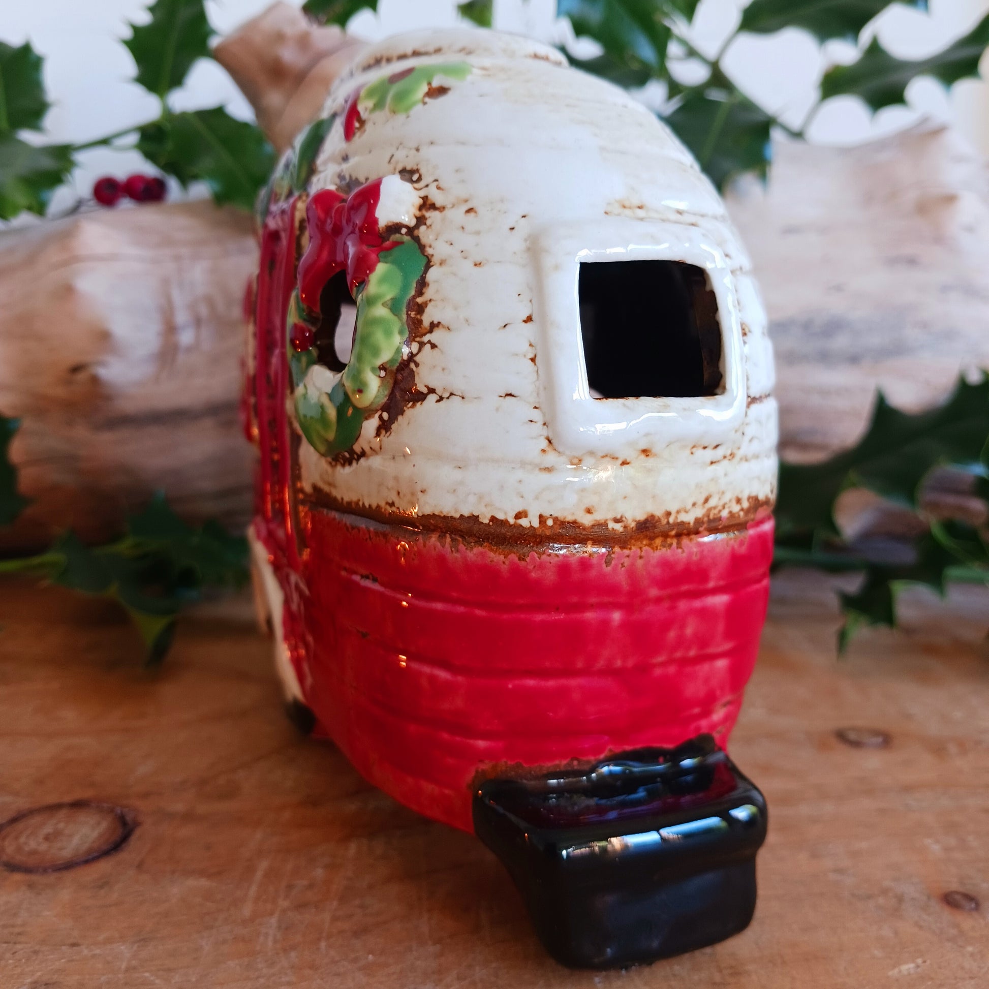 Step into a cosy winter wonderland with the Village Pottery Christmas Caravan Tealight Holder, a heart-warming piece crafted with love and festive magic. Measuring 13.5 x 18.5 x 7 cm, this hand-painted ceramic caravan glows with Christmas cheer, ready to light up your home with a gentle, enchanting flicker.