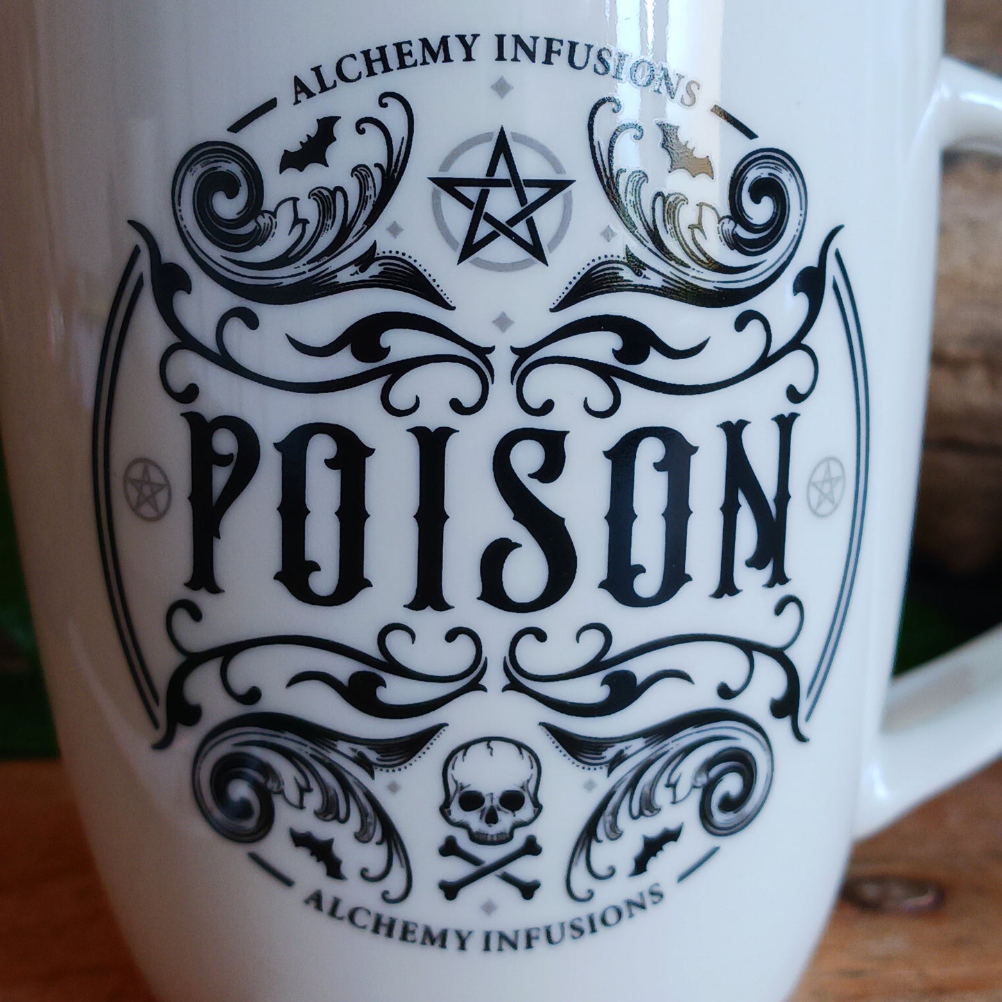The Poison Mug &amp; Spoon Set by Alchemy is crafted for those who know that beauty can deceive and danger can delight. Made from fine white bone china, this striking mug features intricate Alchemy artwork rich with symbolism — skull and crossbones, pentagrams, tiny bats, and ornate swirling patterns that whisper of alchemy, temptation, and forbidden power.