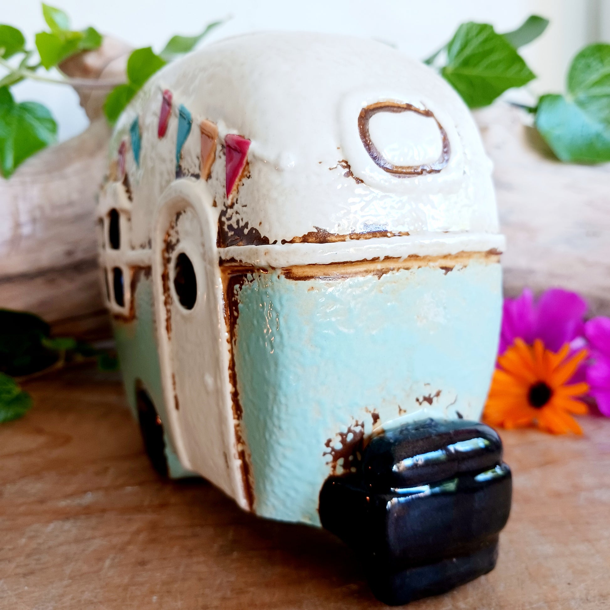 From the enchanted lanes of Village Pottery comes this Aqua Caravan Money Box, a charming ceramic treasure crafted for dreamers and wanderers alike. Measuring 13.5 x 18.5 x 6.5 cm, this delightful piece captures the spirit of adventure with its soft aqua glaze, vintage caravan design, and hand-painted detailing that feels kissed by fairy dust.