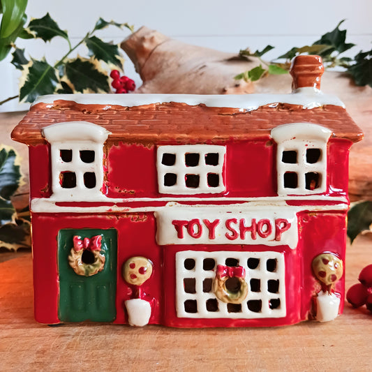 Bring nostalgic festive charm to your home with our Christmas Toy Shop Ceramic Tealight Holder, handcrafted in the Village Pottery workshop. This detailed tealight house captures the magic of an old-world toy shop on a snowy winter’s evening. 