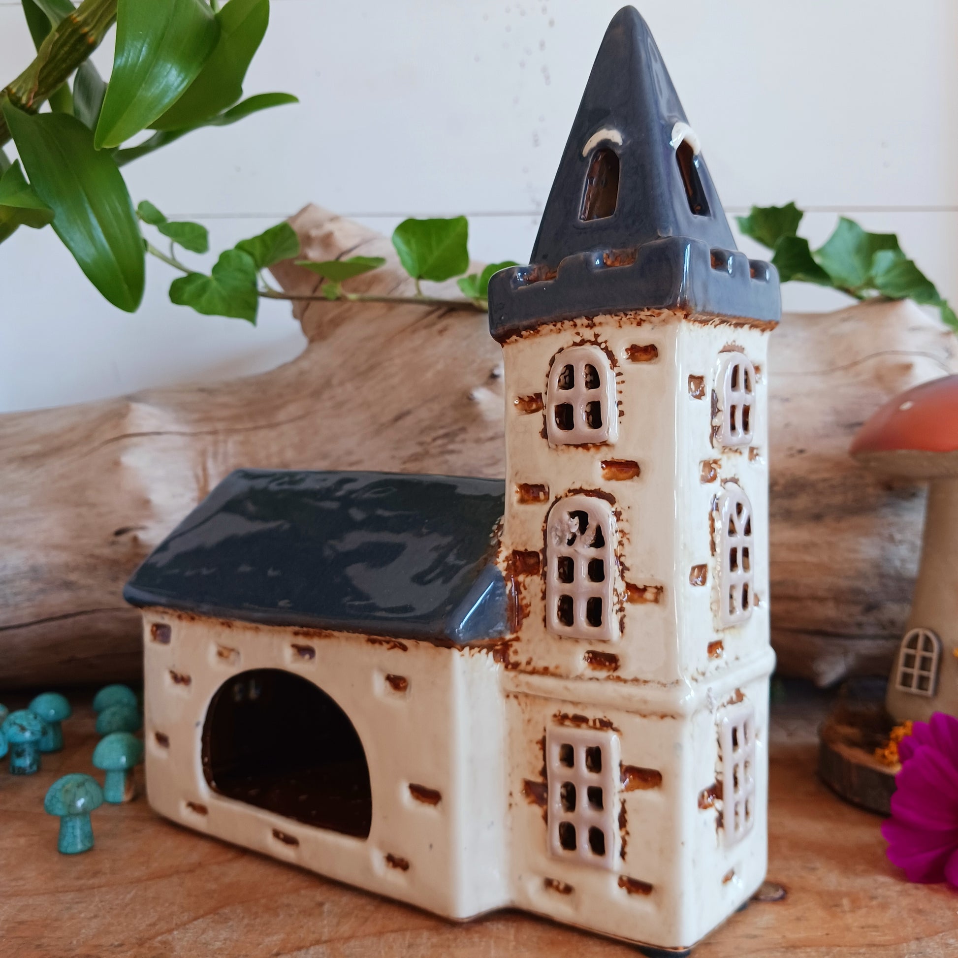 Add timeless charm to your home with the Village Pottery Steeple Church Tealight Holder. Beautifully hand-finished, each ceramic piece is unique and full of character. When a tealight is placed inside, a warm, cosy glow shines through the delicate church windows, creating a magical ambiance. 