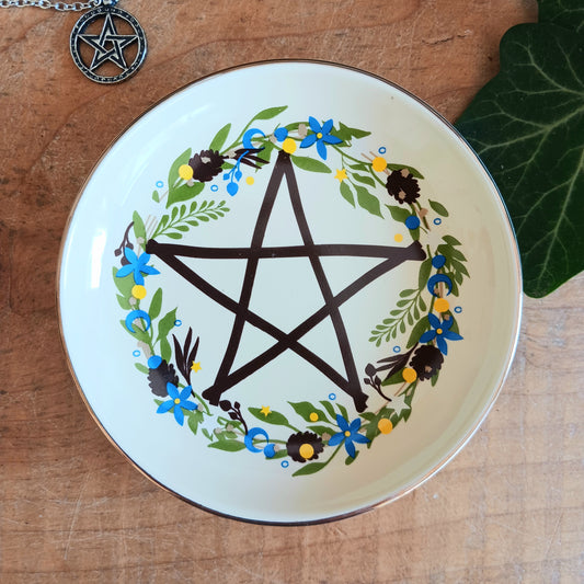 Add a touch of mystical charm to your home with this Solstice Wreath Pentagram Trinket Dish. Beautifully decorated with an elegant botanical pentagram design, this enchanting ceramic dish is perfect for keeping rings, crystals, earrings, necklaces and other tiny treasures safely stored in one place.