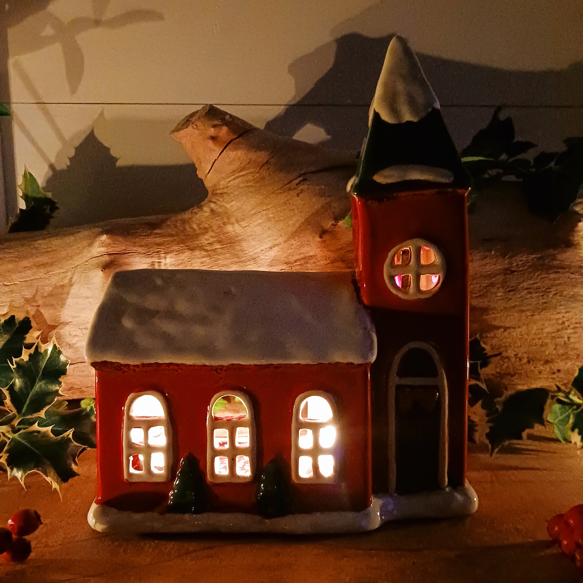 Bring festive warmth to your home with the Large Christmas Church Tealight Holder from the Village Pottery collection. This beautifully handcrafted ceramic piece features rustic detailing, evoking the charm of a snow-covered church glowing softly with candlelight.