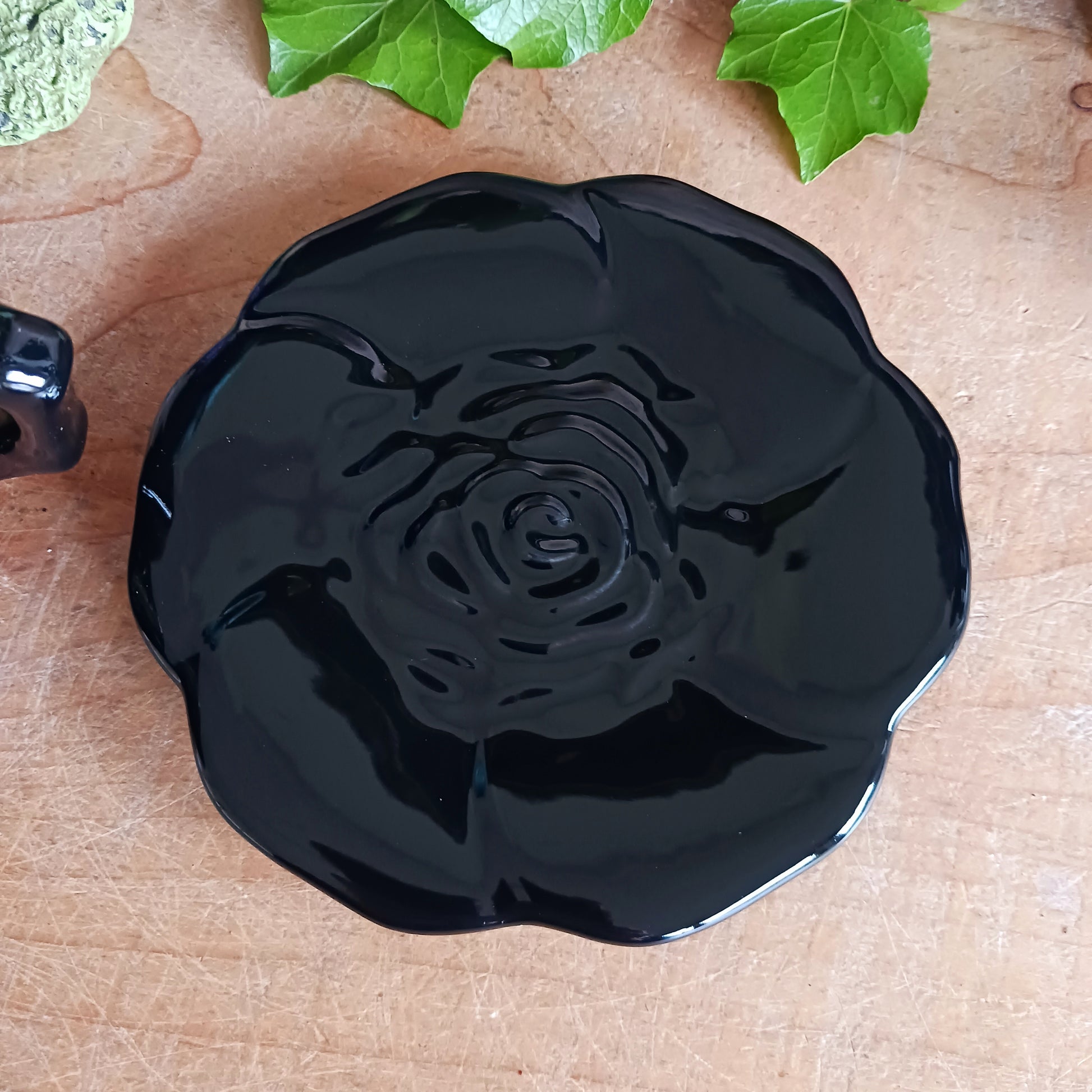 Summon timeless elegance with this black ceramic teacup and matching saucer, sculpted in the likeness of a dark, blooming rose. Designed with a dramatic silhouette and intricate petal detailing, this tea set transforms every sip into a ritual of gothic grace.