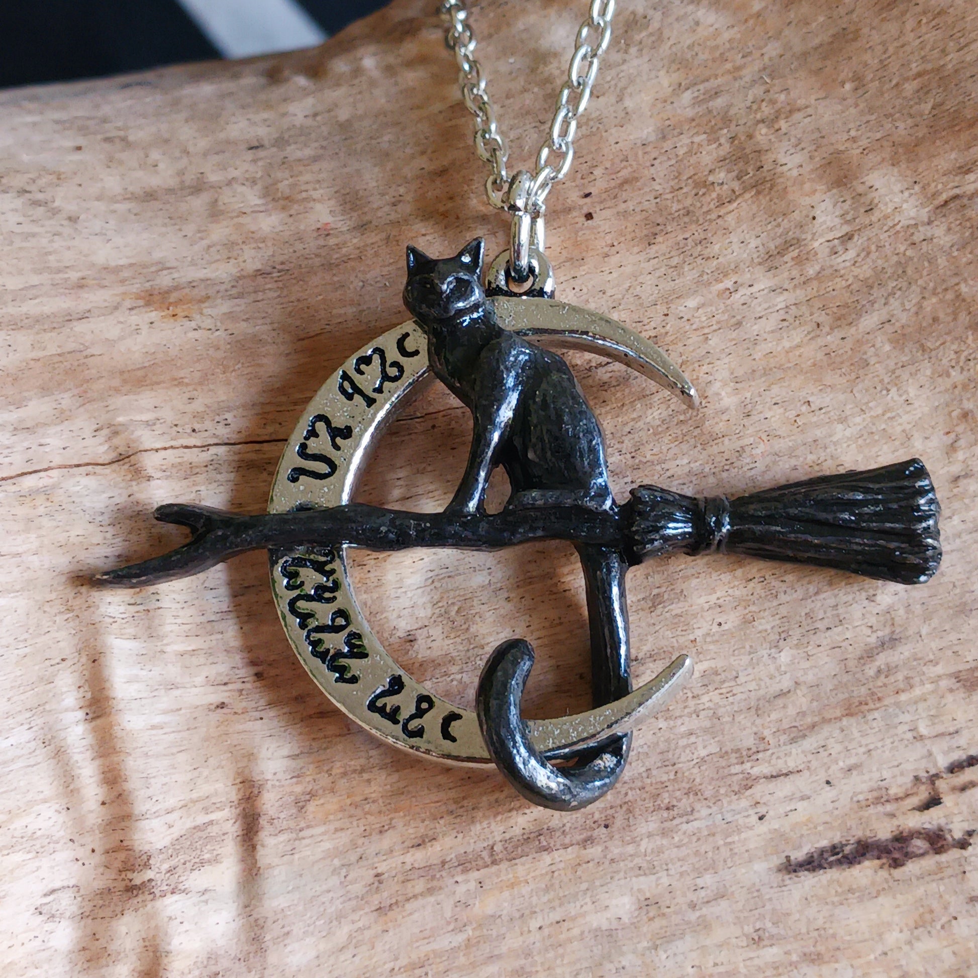 Embrace the magic of the Samhain Sabbat with the Regina Covenorum Necklace. Handcrafted from fine English pewter, this enchanting pendant features a black cat riding a witches’ broom, framed by a polished crescent moon engraved with arcane Theban symbols. Perfect for lovers of mystical jewellery, witchcraft, and celestial-inspired designs, this necklace celebrates the mysterious bond between a witch and her familiar. 