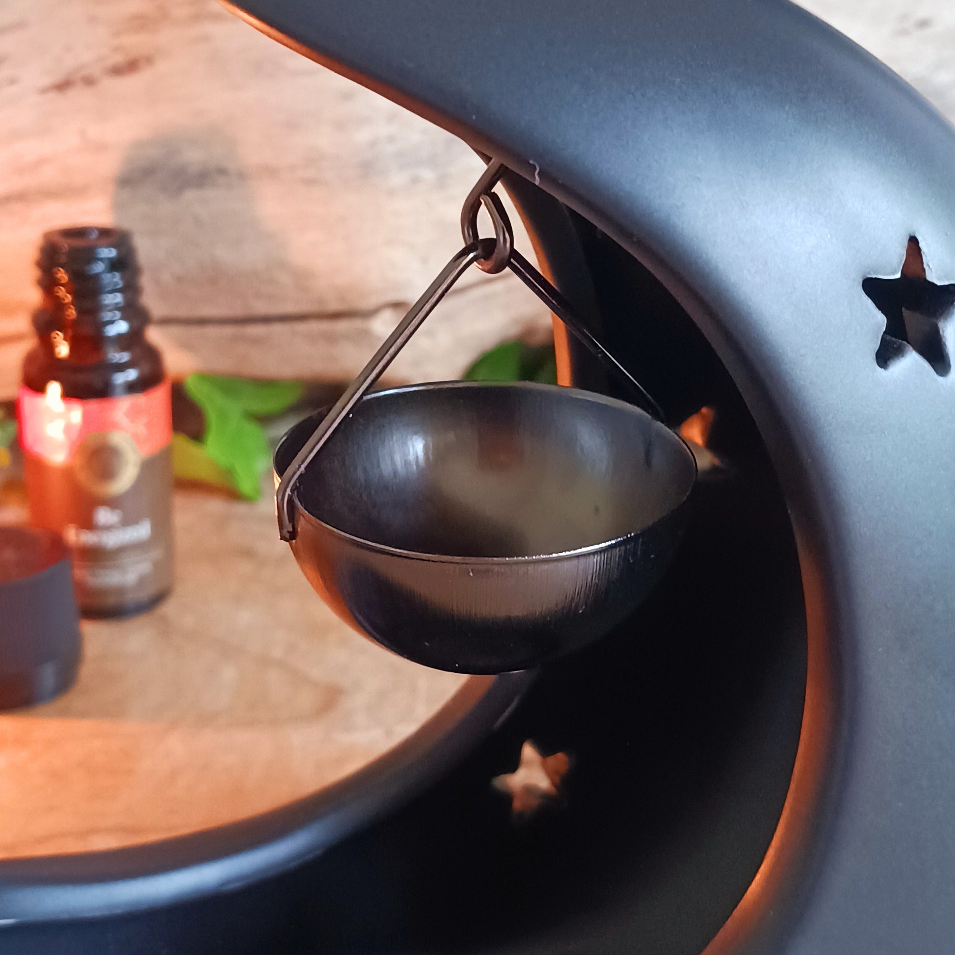 Bring a touch of midnight magic to your home with this enchanting black crescent moon oil burner. Crafted with celestial star cut-outs, it casts a soft, glowing light while infusing the air with your favorite fragrance oil. The hanging bowl design adds a whimsical charm, making it perfect for creating a cozy, dreamy atmosphere in any space. Ideal for relaxing evenings, meditation, or simply adding a mystical statement piece to your décor.