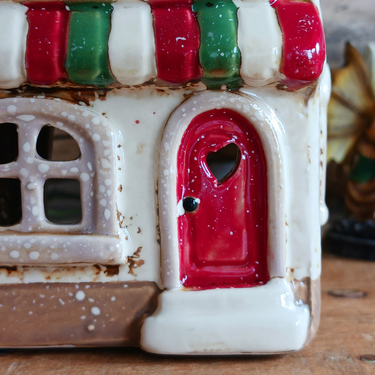 Bring a little taste of Italy into your home with this charming Village Pottery Pizzeria Tealight Holder. Designed as a delightful two-storey Italian village building, this cream pottery house features a brown tiled roof, chimney, green shutters, red flower boxes and colourful red and green striped awnings.