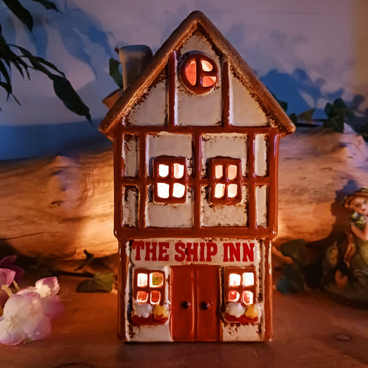 A lantern-lit refuge upon an enchanted street, the Tudor Ship Inn glows with the warmth of stories carried on twilight air. This Shudehill Village Pottery tealight house is crafted from ceramic, its windows flickering with candlelight like a haven for wandering souls.