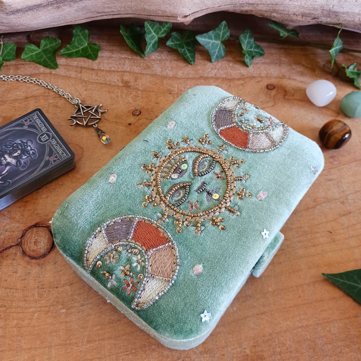Elegant green triple moon velvet box with fine embroidery and beads. Perfect for jewellery, tarot cards, and crystals. Secure strap closure for treasured items.