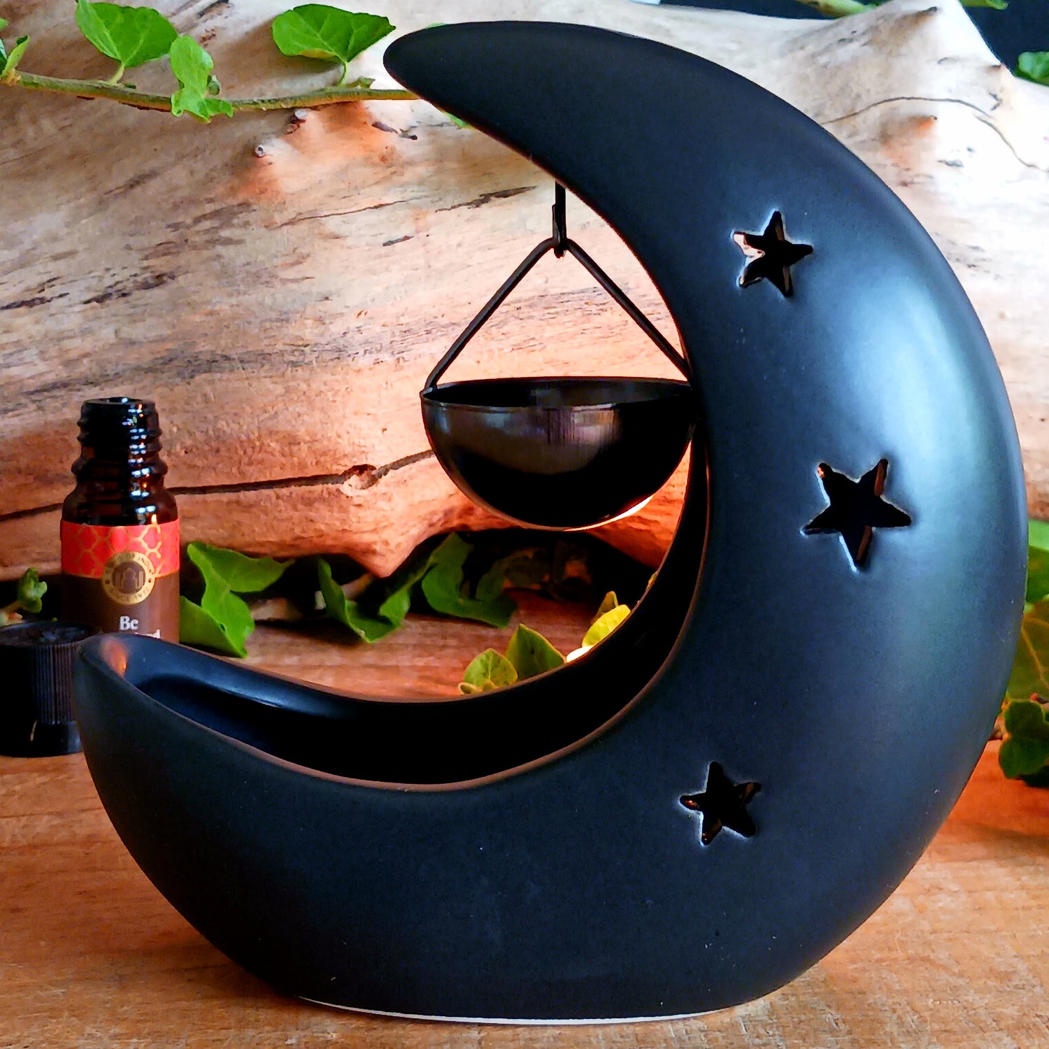 Bring a touch of midnight magic to your home with this enchanting black crescent moon oil burner. Crafted with celestial star cut-outs, it casts a soft, glowing light while infusing the air with your favorite fragrance oil. The hanging bowl design adds a whimsical charm, making it perfect for creating a cozy, dreamy atmosphere in any space. Ideal for relaxing evenings, meditation, or simply adding a mystical statement piece to your décor.