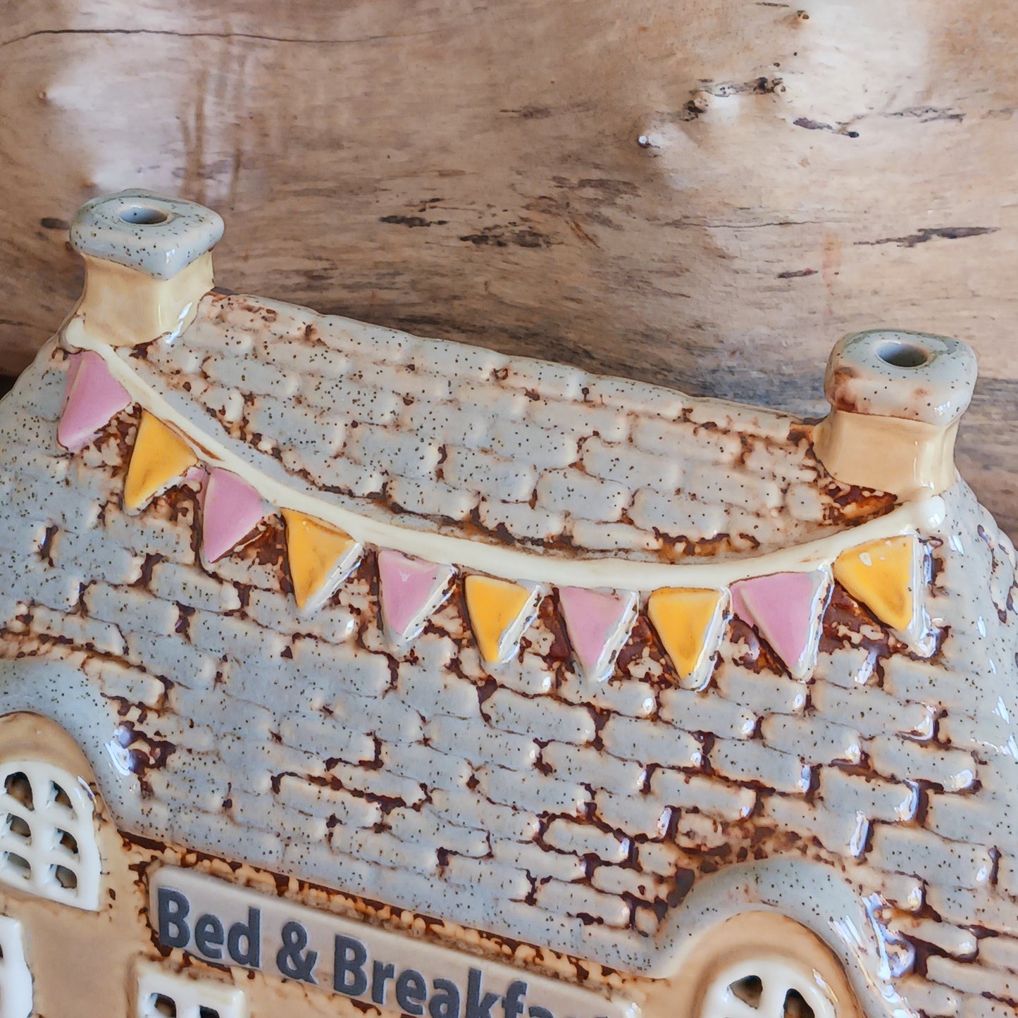 A welcoming glow awaits within this Village Pottery Bed & Breakfast Tealight House, where candlelight flickers through tiny windows like a hearth lit for wandering souls. Crafted from ceramic, this charming inn captures the spirit of an enchanted village, inviting warmth, stillness, and quiet magic into your space.