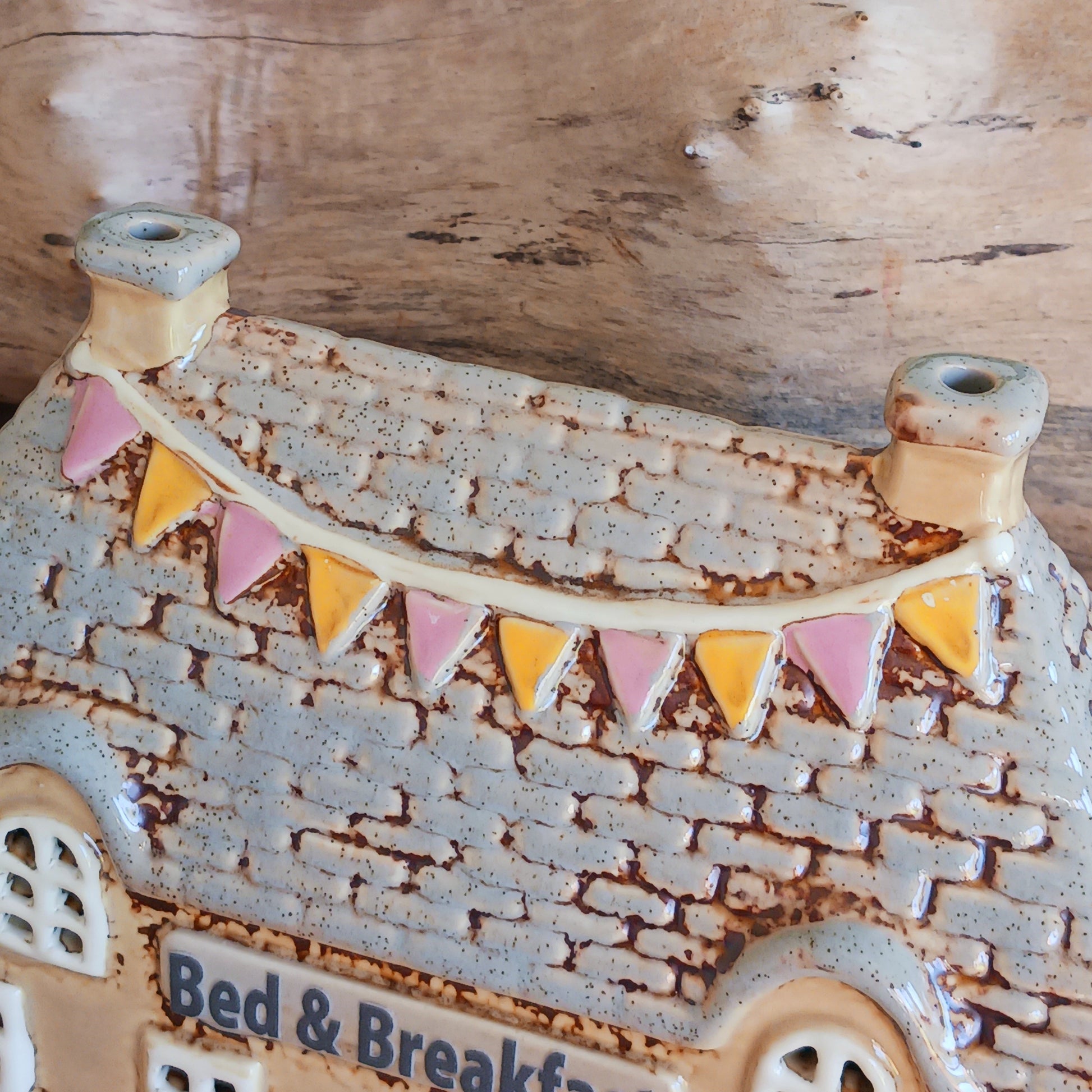 A welcoming glow awaits within this Village Pottery Bed & Breakfast Tealight House, where candlelight flickers through tiny windows like a hearth lit for wandering souls. Crafted from ceramic, this charming inn captures the spirit of an enchanted village, inviting warmth, stillness, and quiet magic into your space.