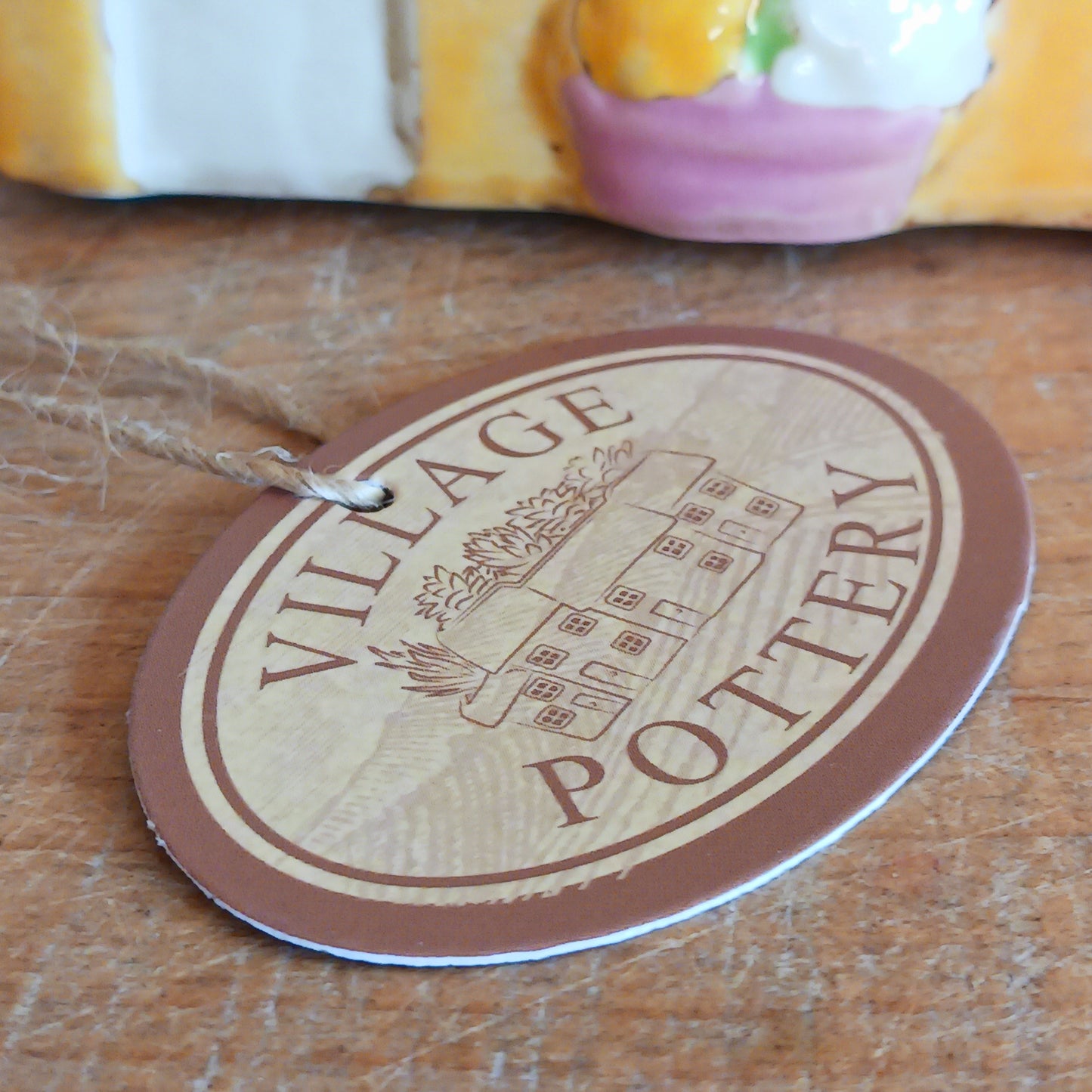 Add a whimsical touch to your décor with the Cards &amp; Gifts Tealight Holder from the Village Pottery Collection. Inspired by the charm of a cozy card shop in a quaint village, this ceramic piece features intricate detailing, from its bunting roof to its delicate windows. Perfect as a tealight holder or simply as a decorative ornament, it brings warmth and character to any space.