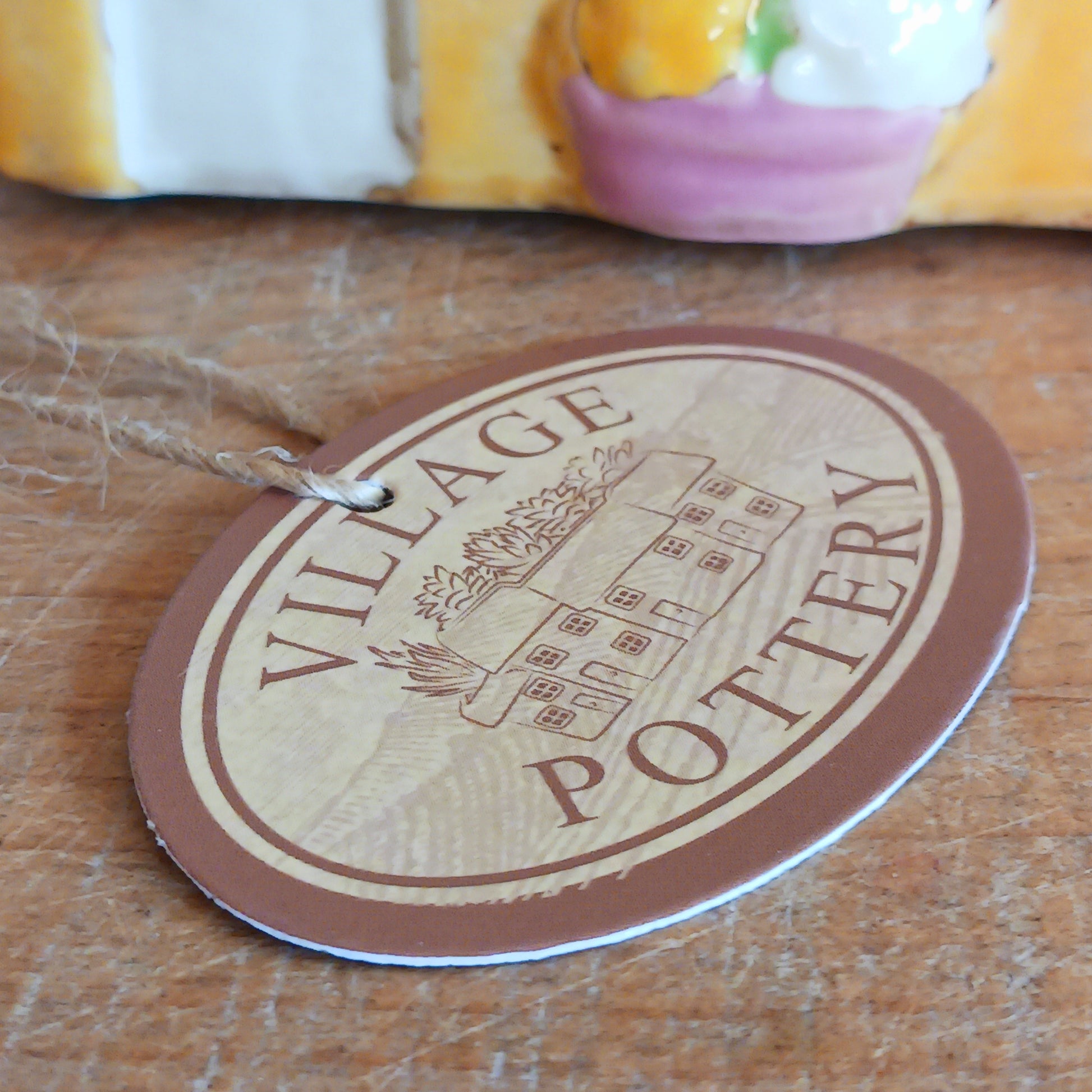 Add a whimsical touch to your décor with the Cards &amp; Gifts Tealight Holder from the Village Pottery Collection. Inspired by the charm of a cozy card shop in a quaint village, this ceramic piece features intricate detailing, from its bunting roof to its delicate windows. Perfect as a tealight holder or simply as a decorative ornament, it brings warmth and character to any space.