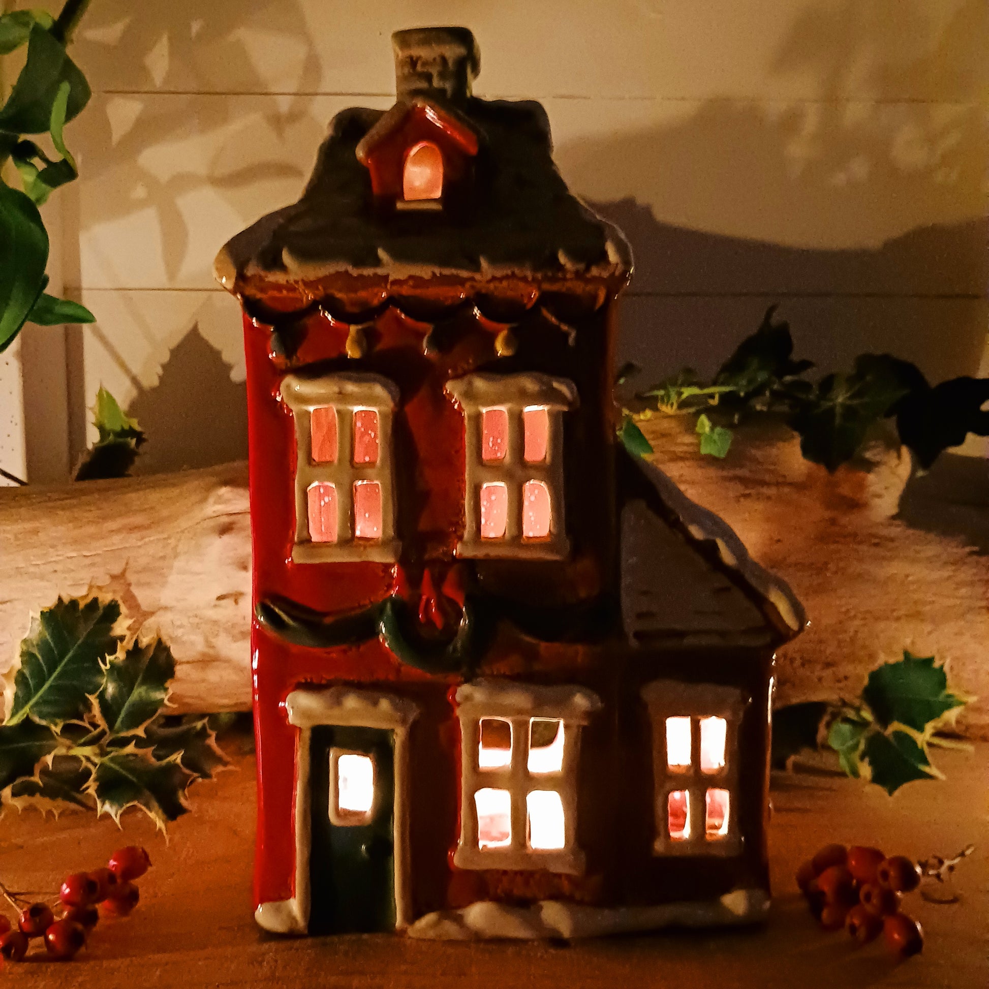 Bring the warmth and magic of Christmas into your home with this handcrafted Christmas Wreath House Tealight Holder from the Village Pottery collection. Made from high-quality ceramic and decorated with a classic wreath and rustic detailing, this piece evokes the charm of a snowy winter’s evening.