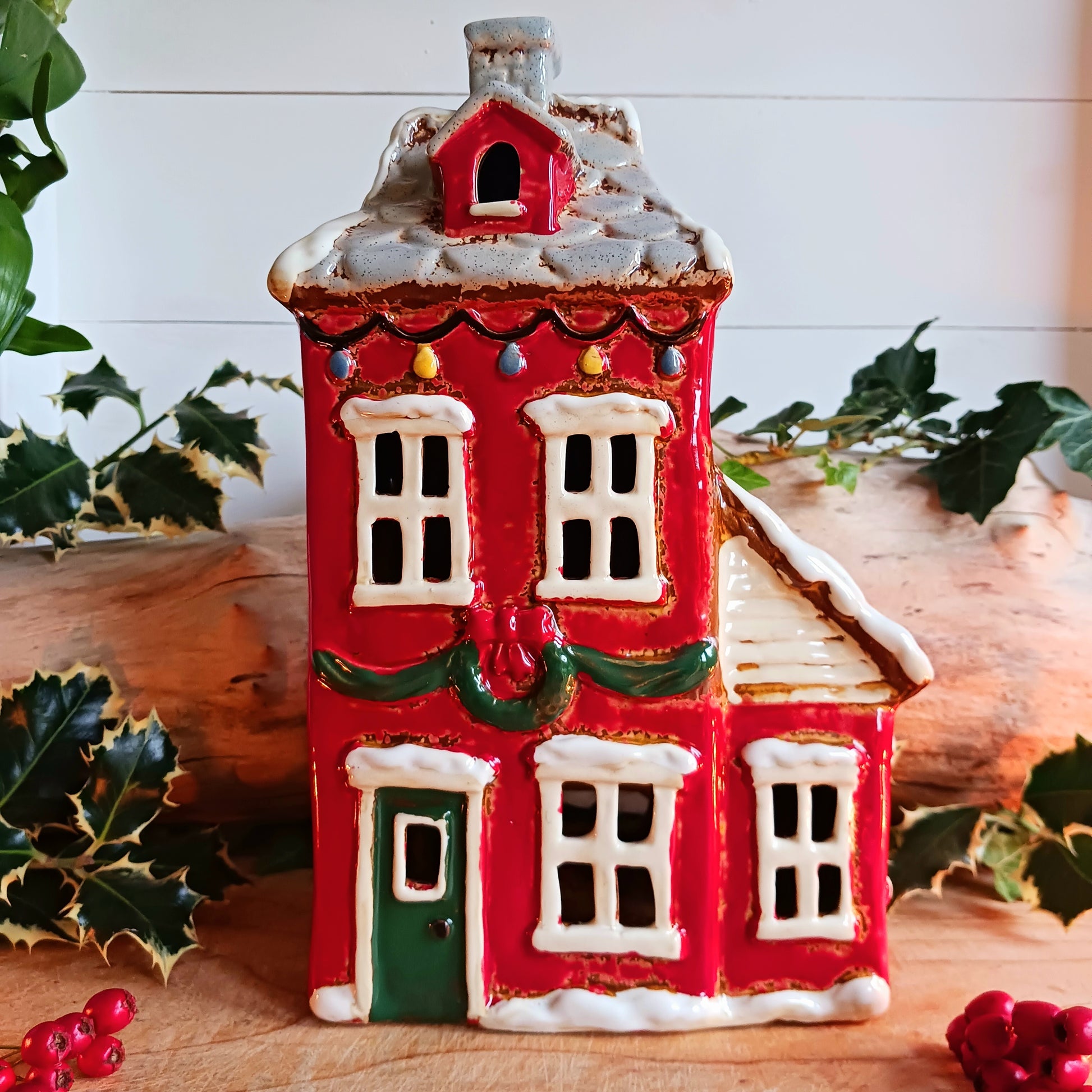 Bring the warmth and magic of Christmas into your home with this handcrafted Christmas Wreath House Tealight Holder from the Village Pottery collection. Made from high-quality ceramic and decorated with a classic wreath and rustic detailing, this piece evokes the charm of a snowy winter’s evening.