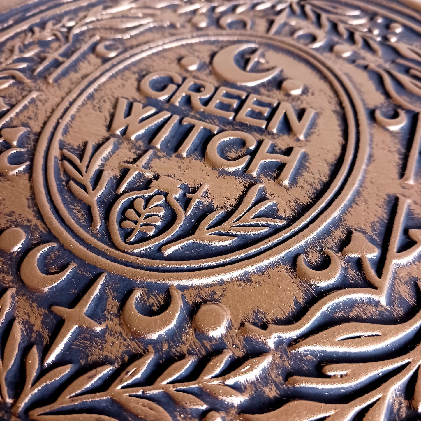 The Green Witch Bronze Effect Terracotta Hanging Plaque infuses your space with grounded, earthy energy and ancient symbolism.