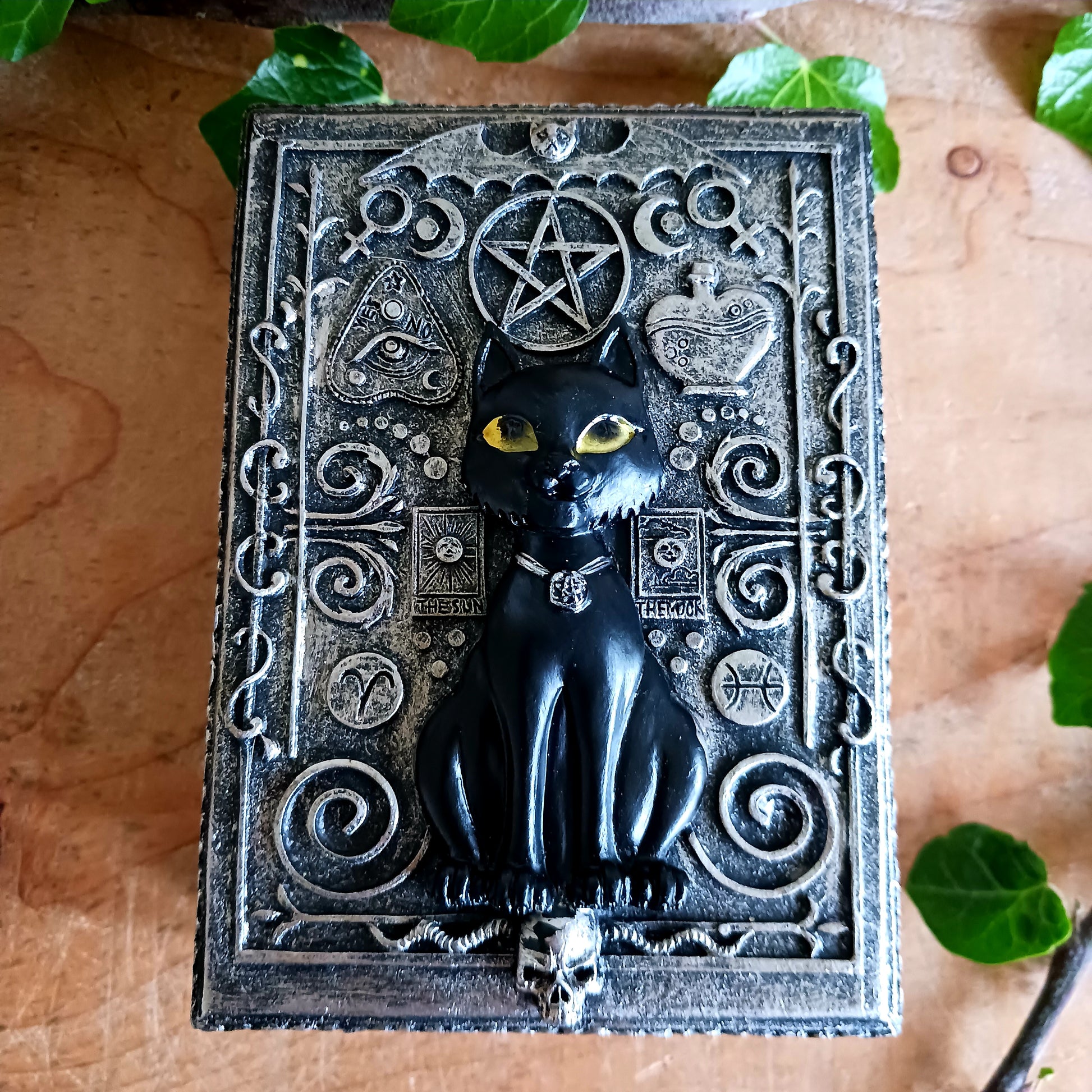 From the macabre masters at Nemesis Now, this Black Cat Familiar Box is a must-have for any occult enthusiast. At its centre sits a mystical black cat familiar perched atop a horned skull, radiating dark enchantment and protective energy.