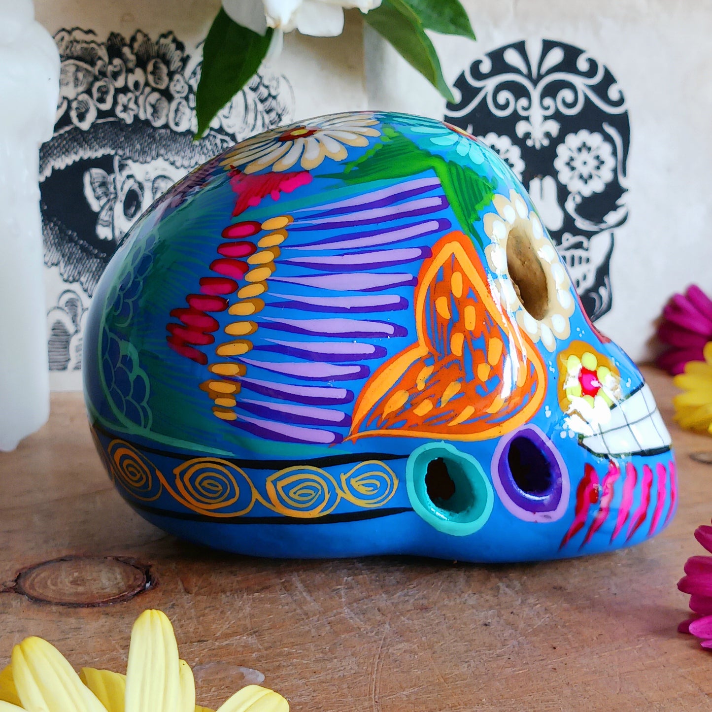 These fun ceramic sugar skull ornaments have been beautifully painted in bright colours and finished with a high shine glaze. They are a popular item during Día de Los Muertos or Day of the Dead festivities, held in Mexico every November to celebrate welcoming the souls of their deceased relatives back for a time of food, drink and celebration.