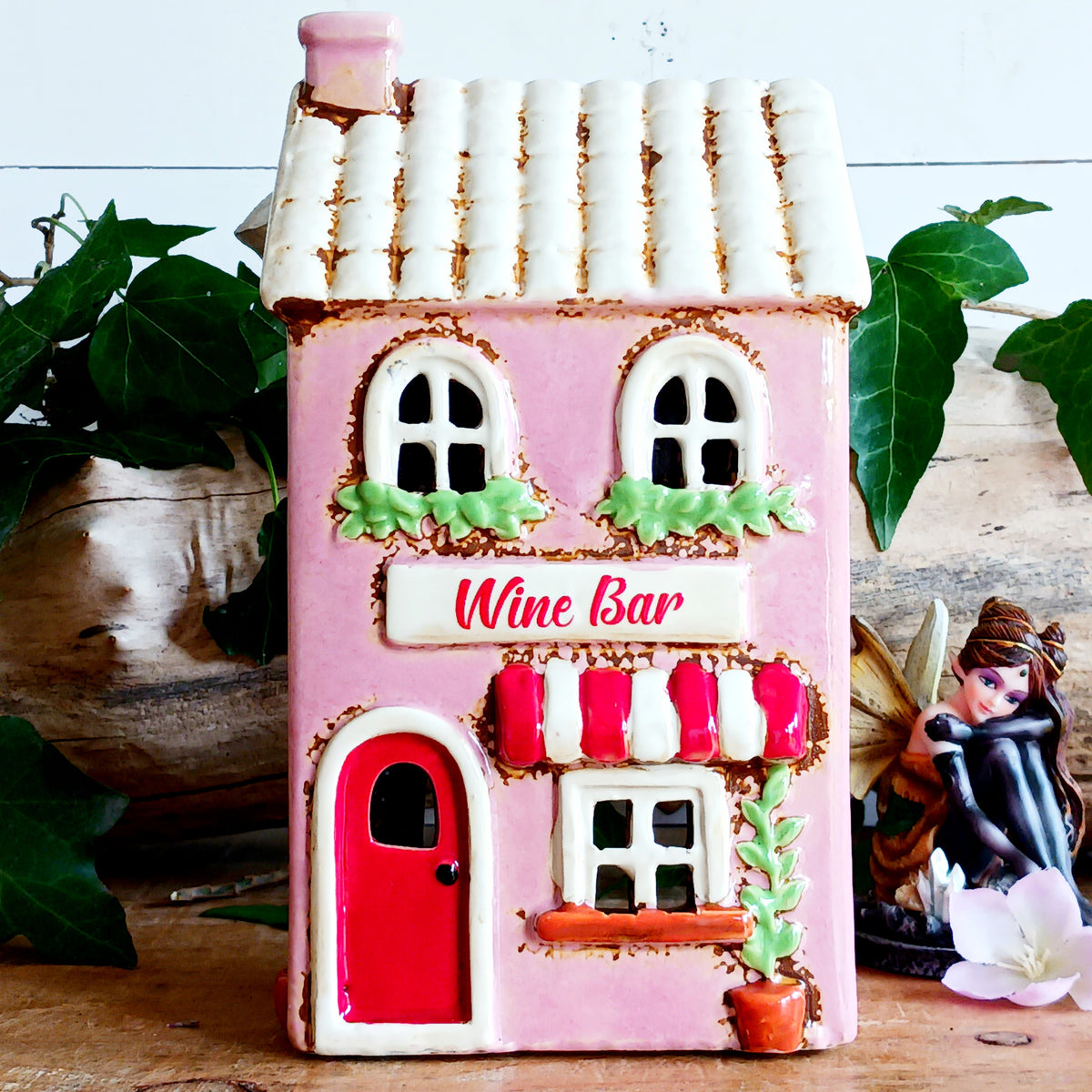 Bring the charm of a quaint village high street into your home with this delightful Village Pottery Wine Bar Tealight Holder. Hand-crafted from ceramic and beautifully hand-painted, this charming miniature wine bar is packed with character and intricate details.