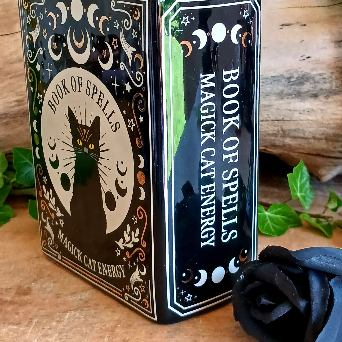 Bring a touch of dark enchantment to your home décor with the Black Cat Spell Book Ceramic Vase. Designed to resemble an ancient magical spell book, this unique ceramic vase transforms fresh flowers, dried stems, or decorative arrangements into a captivating gothic display. Featuring an elegant black cat-inspired design, it’s the perfect statement piece for bookshelves, side tables, mantels, or altar-inspired interiors.