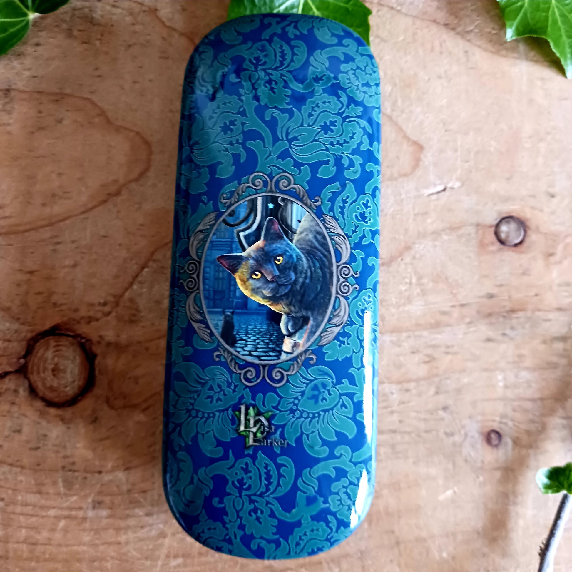 Protect your spectacles in enchanting style with this hard shell glasses case featuring Lisa Parker’s ‘Rusty Cauldron’ artwork. Designed to guard your eyewear from scratches, pressure, and everyday wear, this sturdy case is perfect for handbags, backpacks, or bedside storage.
