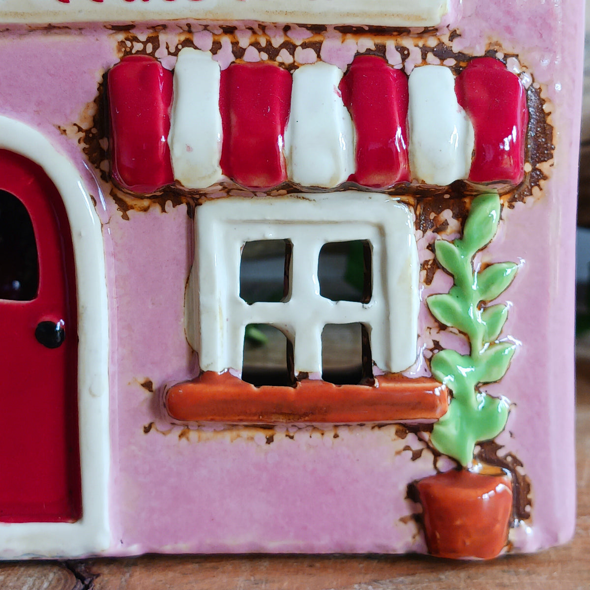 Bring the charm of a quaint village high street into your home with this delightful Village Pottery Wine Bar Tealight Holder. Hand-crafted from ceramic and beautifully hand-painted, this charming miniature wine bar is packed with character and intricate details.