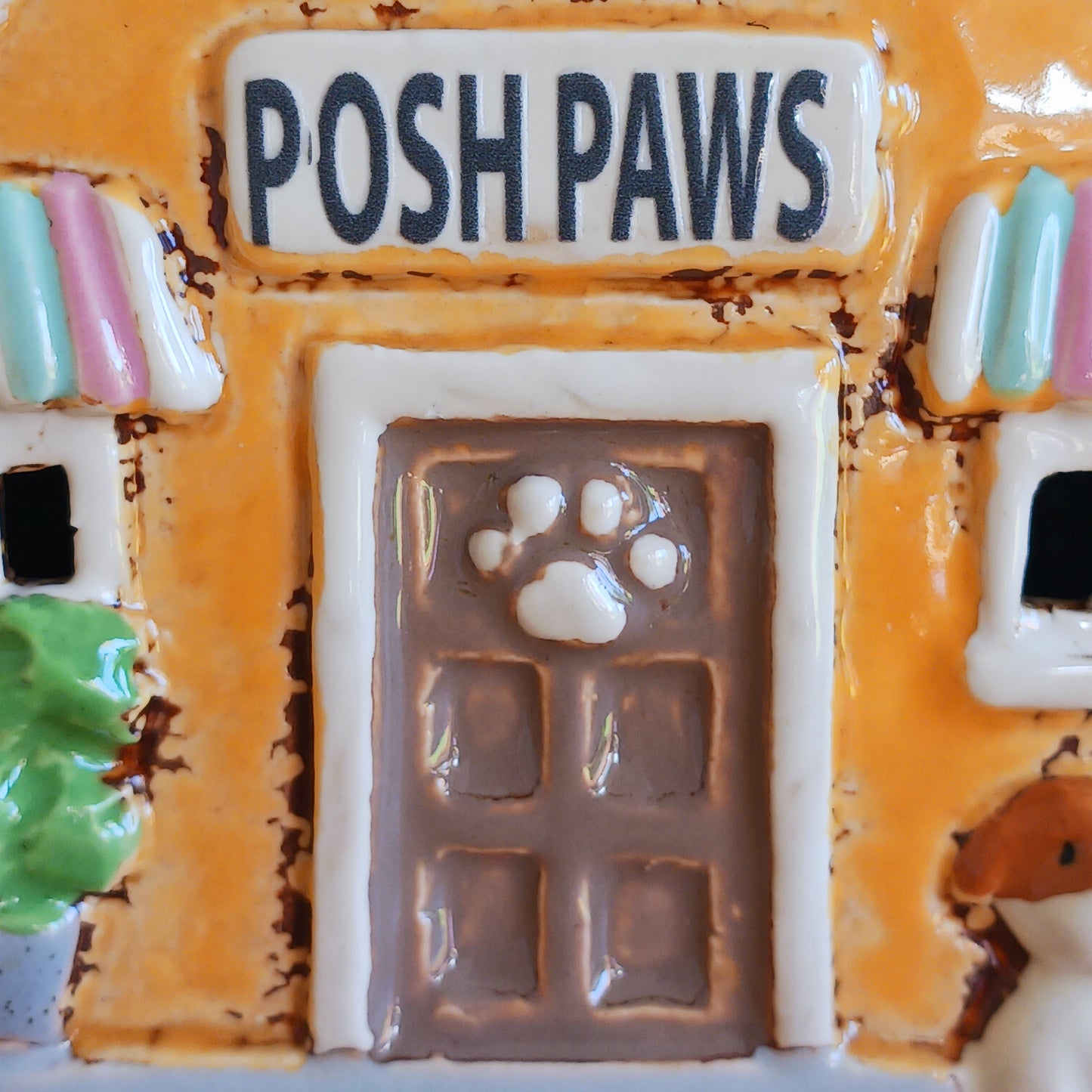 A gentle glow shines from Posh Paws, where tiny windows flicker with warmth as if welcoming beloved companions into a magical village haven. This Shudehill Village Pottery tealight house is crafted from ceramic, allowing candlelight to dance softly through its details, creating a comforting and enchanted atmosphere.