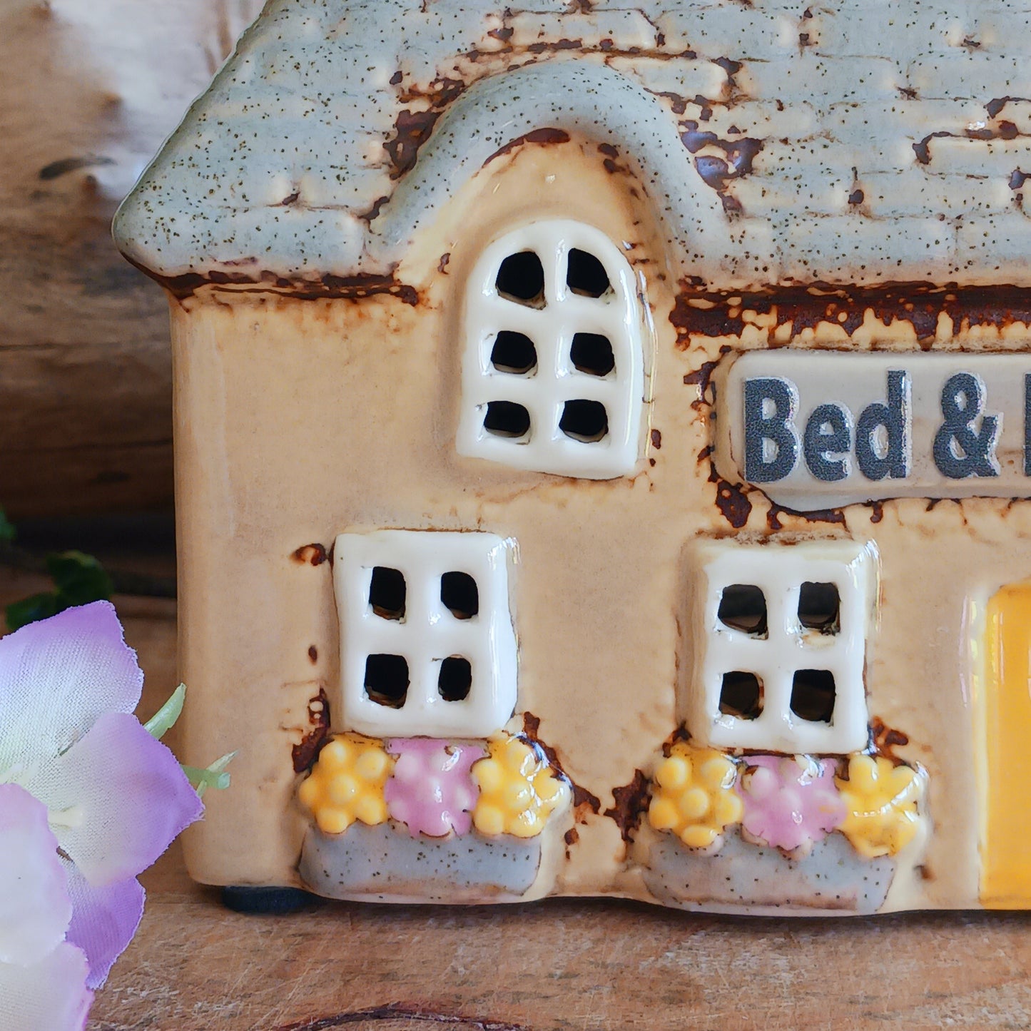 A welcoming glow awaits within this Village Pottery Bed & Breakfast Tealight House, where candlelight flickers through tiny windows like a hearth lit for wandering souls. Crafted from ceramic, this charming inn captures the spirit of an enchanted village, inviting warmth, stillness, and quiet magic into your space.