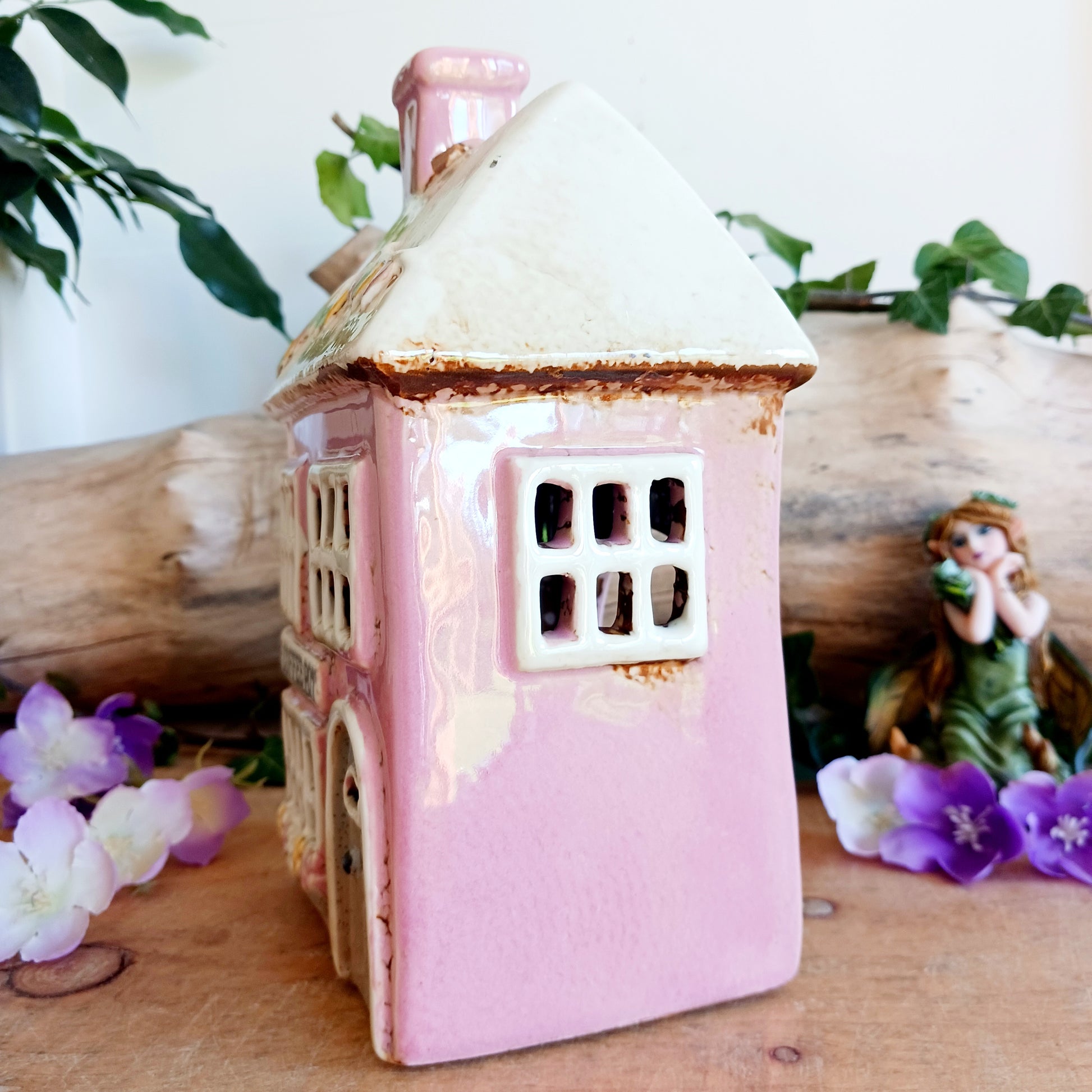 A comforting glow brews within the Coffee Pot Shop, where candlelight flickers like steam rising from a warm cup in a quiet enchanted village. This Shudehill Village Pottery tealight house is crafted from ceramic, casting a soft, golden light through its windows to create a scene of calm and gentle magic.