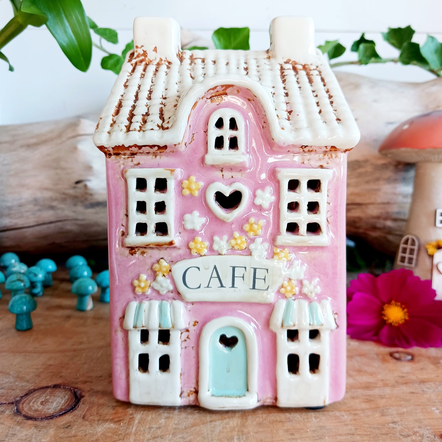 Illuminate your home with the charming Village Pottery Café Tealight Holder. Handcrafted with a rustic pink finish, this cosy piece adds warmth and ambience to any room. Perfect for tealights or simply as a decorative ornament, it’s a delightful addition to shelves, windowsills, or coffee tables. Pair with other pieces from the Village Pottery Collection to create your own quaint, decorative village.