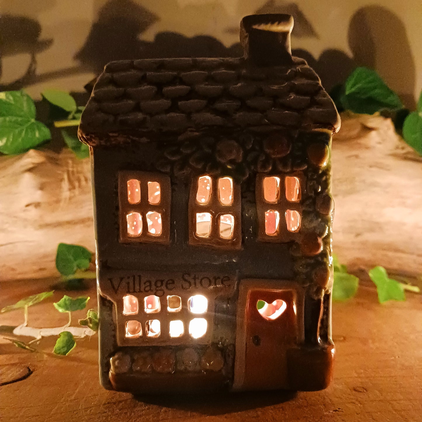 Welcome a touch of storybook charm into your home with the Village Pottery Village Stores Tealight Holder, a handcrafted ceramic delight glowing with the warmth of simpler times. Measuring 15.5 x 9.5 x 8 cm, this quaint miniature shop captures the heart of an old-fashioned village, complete with detailed windows, rustic roof tiles, and painted signage that evokes cosy nostalgia.