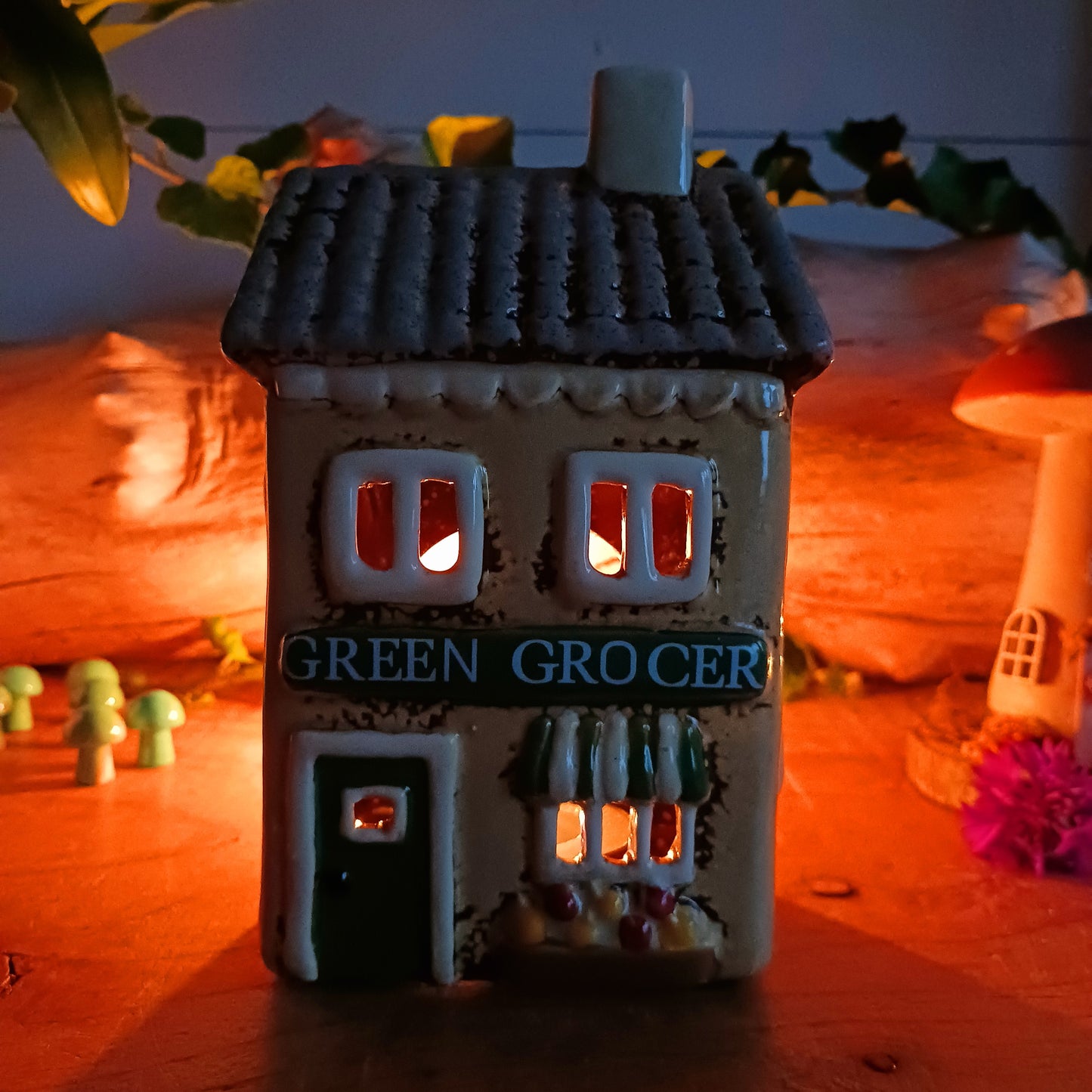 Illuminate your home with the charming Village Pottery Green Grocers Shop Tealight Holder. Handcrafted with a rustic green finish, this cosy piece adds warmth and ambience to any room. Perfect for tealights or simply as a decorative ornament, it’s a delightful addition to shelves, windowsills, or coffee tables. Pair with other pieces from the Village Pottery Collection to create your own quaint, decorative village.