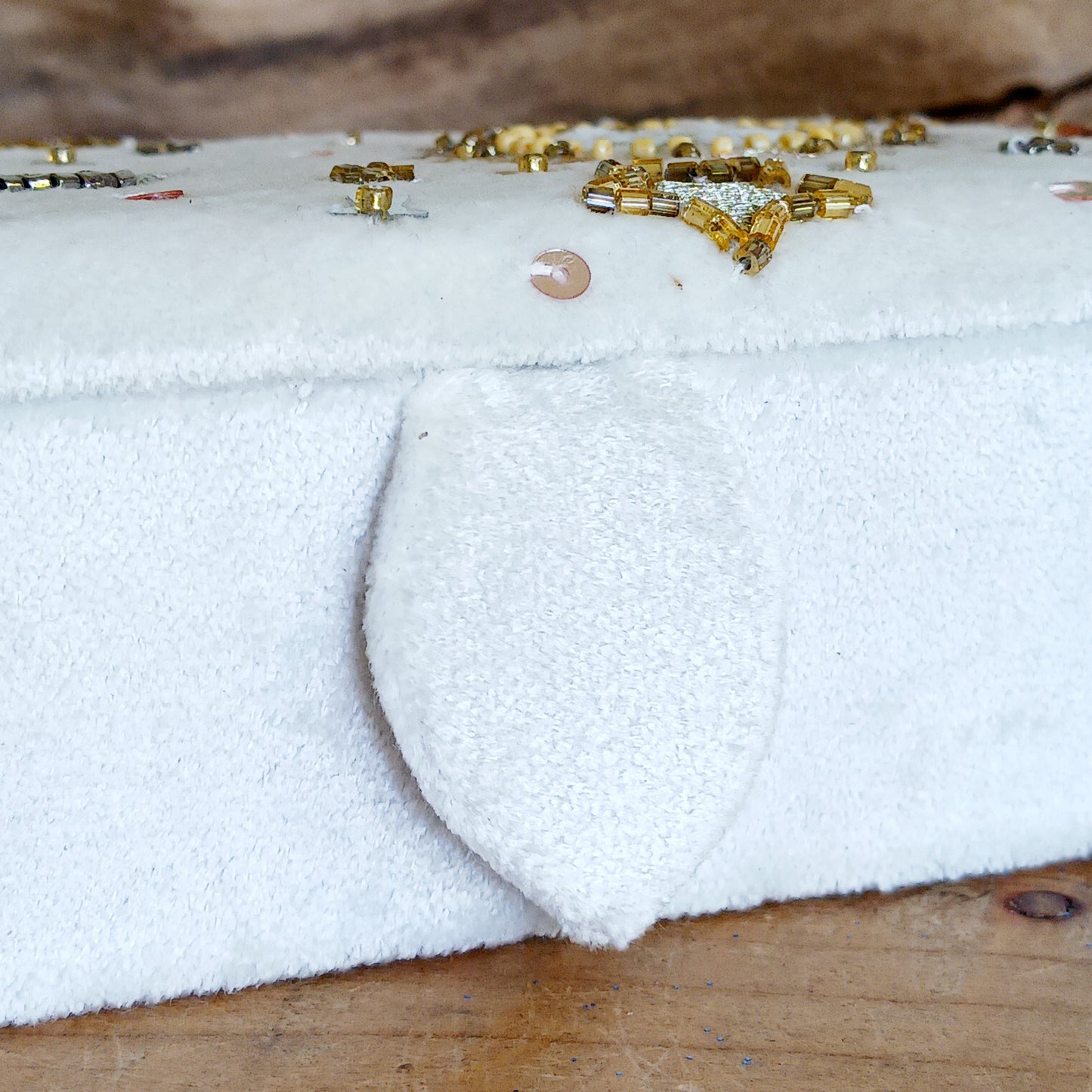 Add elegance and mystique to your collection with this finely embroidered jewellery and tarot box. Made in India and crafted from soft velvet in white, this piece is adorned with intricate embroidery and golden ornamental beads for a touch of luxury. Perfect for storing jewellery, tarot cards, crystals, or other cherished items, its small strap and button closure keep your treasures secure.