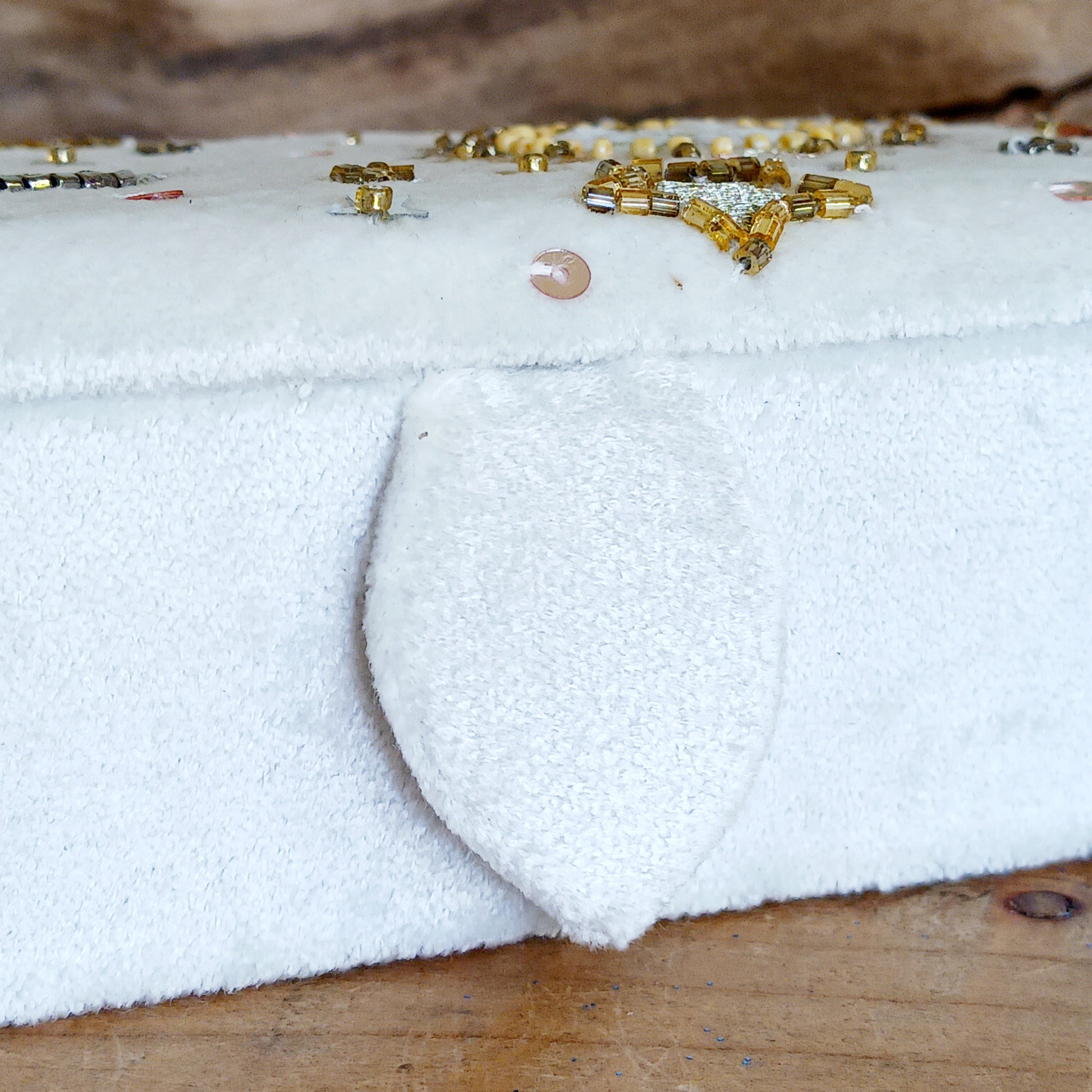 Add elegance and mystique to your collection with this finely embroidered jewellery and tarot box. Made in India and crafted from soft velvet in white, this piece is adorned with intricate embroidery and golden ornamental beads for a touch of luxury. Perfect for storing jewellery, tarot cards, crystals, or other cherished items, its small strap and button closure keep your treasures secure.