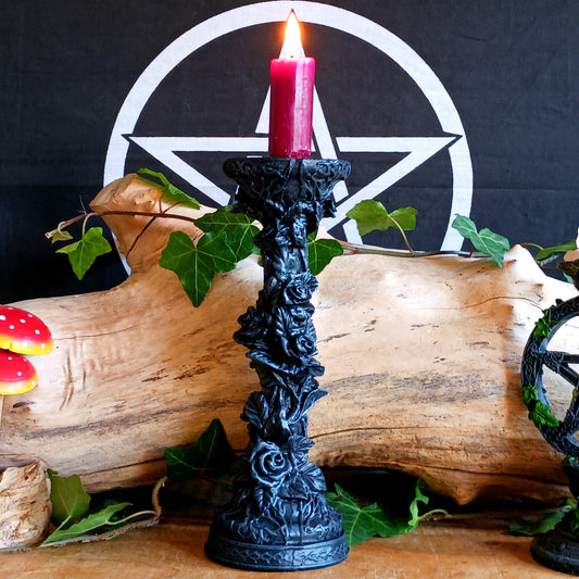 Add a touch of dark elegance to your home with the Midnight Rose Gothic Candlestick Holder. Beautifully crafted with a stone pillar design, this striking ornament features intricate black roses and dark vegetation, creating a mysterious gothic aesthetic that makes a statement in any room.