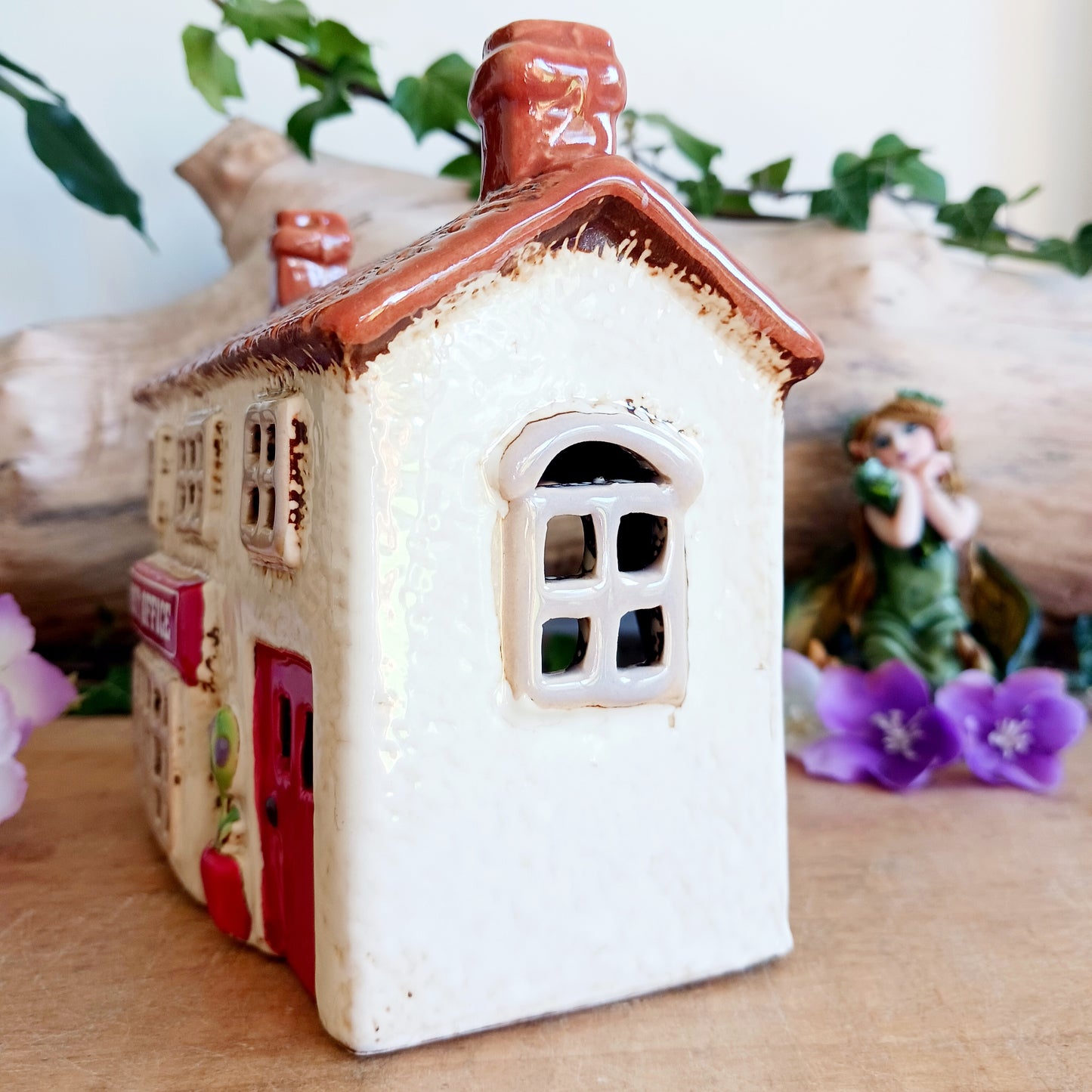 Whispers travel by candlelight from this Village Pottery Post Office tealight house, where tiny windows glow like messages carried between realms. Crafted from ceramic and measuring 12x15x7cm, this enchanting piece brings warmth and quiet magic to your sacred space.