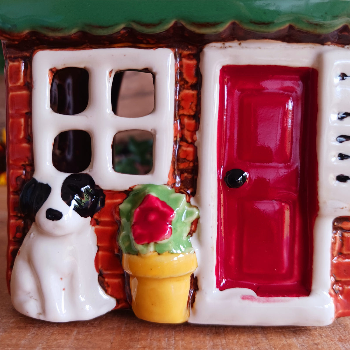 Bring a touch of village charm to your home with the Village Pottery Newsagent Tealight Holder. Beautifully designed as a traditional little village newsagent, this charming ceramic tealight holder features a warm red-brick façade, textured cream tiled roof and cheerful bright red front door.