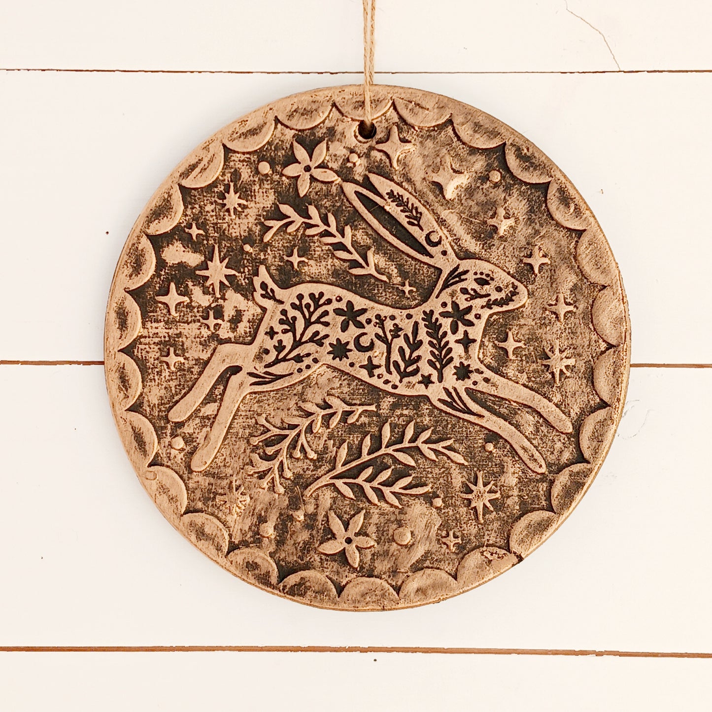 Add a touch of seasonal magic to your home or garden with this enchanting Winter Solstice Hare Hanging Plaque. Crafted from terracotta and finished with an attractive brushed bronze effect, the plaque features an elegant leaping hare surrounded by intricate botanical detailing inspired by the beauty of the natural world.