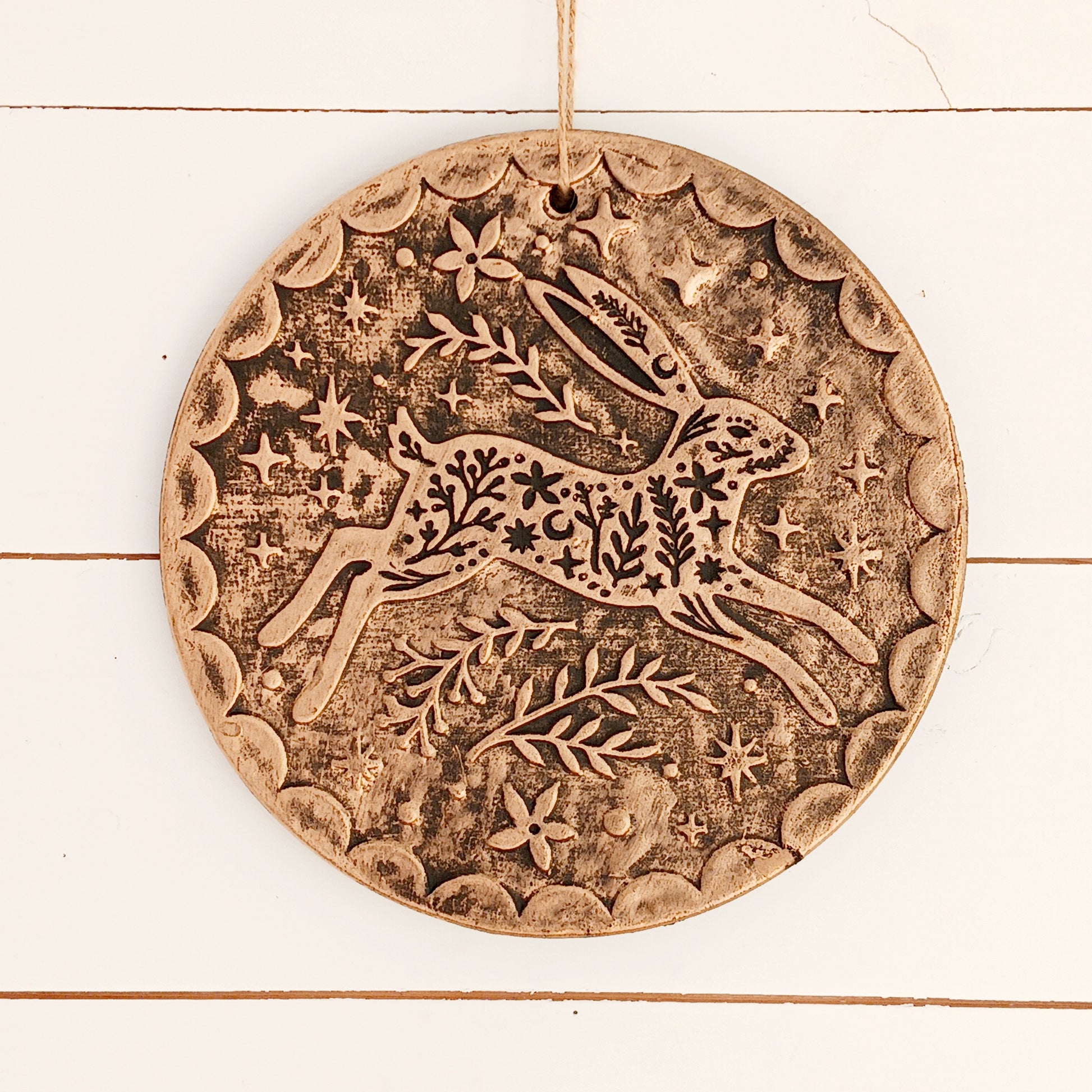 Add a touch of seasonal magic to your home or garden with this enchanting Winter Solstice Hare Hanging Plaque. Crafted from terracotta and finished with an attractive brushed bronze effect, the plaque features an elegant leaping hare surrounded by intricate botanical detailing inspired by the beauty of the natural world.