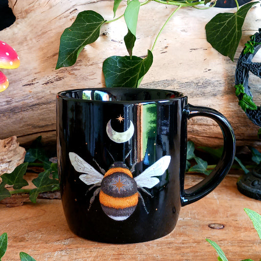 Add a touch of enchantment to your morning coffee or tea with this beautiful Dark Forest Bee Ceramic Mug. Featuring an intricate woodland-inspired design with a delicate bee, crescent moon and twinkling stars, this charming mug brings a little magic to every cuppa.