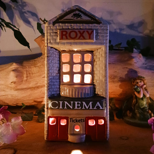 Step into a twilight screening where candlelight flickers like scenes upon an unseen reel. The Shudehill Village Pottery Roxy Cinema tealight house is crafted from ceramic, casting a soft glow through its windows to evoke a nostalgic yet enchanted village night.